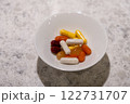 カラフルなサプリメントが入った白い皿と健康管理 122731707