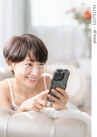 スマホを見て笑顔になるミドルの女性 122731741