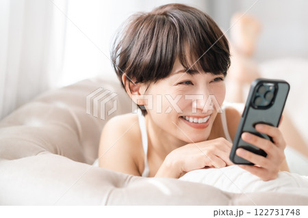 スマホを見て笑顔になるミドルの女性 スマホを見て笑顔になるミドルの女性 122731748