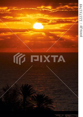 the full beautiful round sun rises over the atlantic in the early morning on the Canary Island of Fuerteventura the full beautiful round sun rises over the atlantic in the early morning on the Canary Island of Fuerteventura 122731749