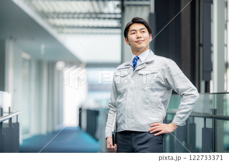 オフィスの廊下に立つ作業服の男性 122733371