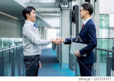 握手 作業着の男性とスーツの男性 握手 作業着の男性とスーツの男性 122733377