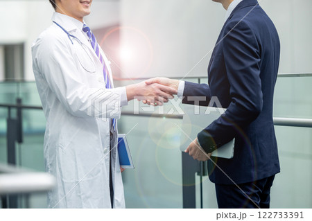 握手をする医師とビジネスマン 122733391