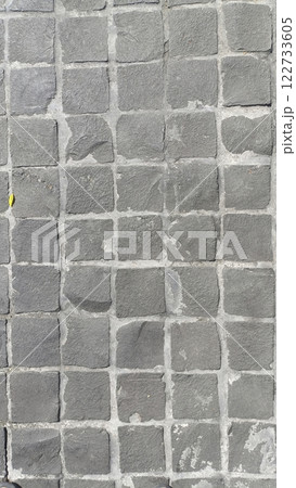 A Textured gray cobblestone pavement with uniform pattern, ideal for urban settings A Textured gray cobblestone pavement with uniform pattern, ideal for urban settings 122733605