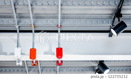 Electrical cable conduit wiring with colorful junction box and exhibition lamp on metallic ceiling 122735212