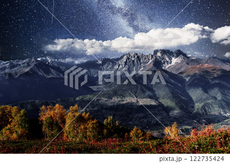 Autumn landscape and snow mountains in beautiful cumulus clouds. Main Caucasian Ridge. Type Mount Ushba Mheyer, Georgia Autumn landscape and snow mountains in beautiful cumulus clouds. Main Caucasian Ridge. Type Mount Ushba Mheyer, Georgia 122735424