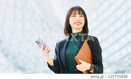 スマートフォンを持つ笑顔の女性・ビジネスウーマン スマートフォンを持つ笑顔の女性・ビジネスウーマン 122735696