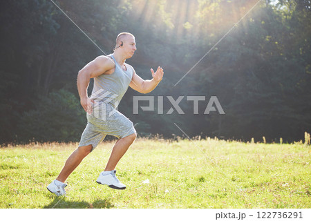 Fitness man athlete jogging in the nature during sunset. Person running working out living an active lifestyle training cardio in summer in sportswear and shoes. 122736291