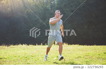 Fitness man athlete jogging in the nature during sunset. Person running working out living an active lifestyle training cardio in summer in sportswear and shoes. 122736293