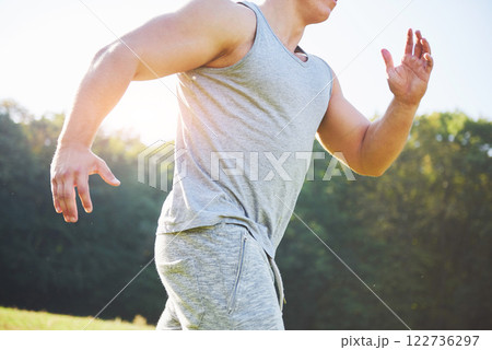 Fitness man athlete jogging in the nature during sunset. Person running working out living an active lifestyle training cardio in summer in sportswear and shoes. 122736297