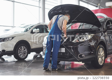 Picture showing muscular car service worker repairing vehicle 122736550