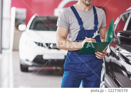 Hand of car mechanic with wrench. Auto repair garage 122736570
