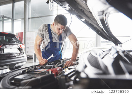 Picture showing muscular car service worker repairing vehicle Picture showing muscular car service worker repairing vehicle 122736590