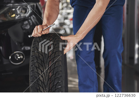 Close up of mechanic showing ok gesture with his thumb while holding a wrench Close up of mechanic showing ok gesture with his thumb while holding a wrench 122736630