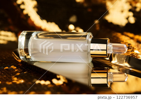 A bottle of cosmetic serum with a pipette on a festive golden background. 122736957