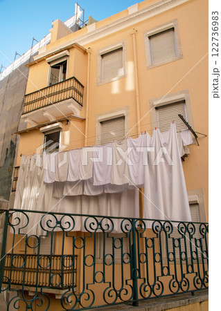 White linen drying on a rope in the sun, clotheslines in an old town in Lisbon, Portugal 122736983