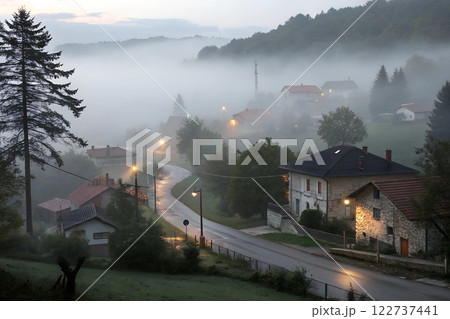 Serene small village with houses softly veiled by a thick, mystical fog	 122737441