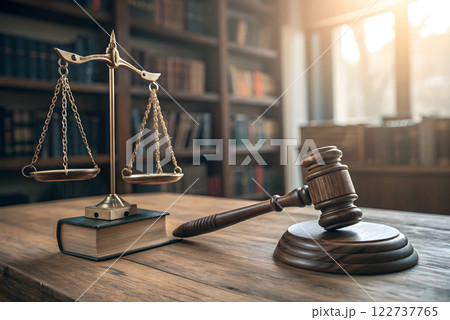 A photorealistic image of a judge's gavel and a scale of justice in a courtroom setting. The image should focus on the gavel and the scale of justice A photorealistic image of a judge's gavel and a scale of justice in a courtroom setting. The image should focus on the gavel and the scale of justice 122737765