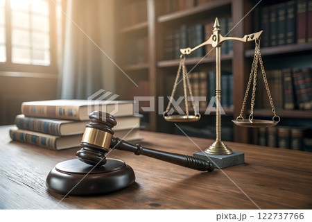 A photorealistic image of a judge's gavel and a scale of justice in a courtroom setting. The image should focus on the gavel and the scale of justice 122737766