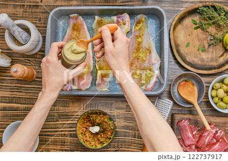 Preparing flavorful seasoning for fresh fish fillets in a cozy kitchen setting 122737917