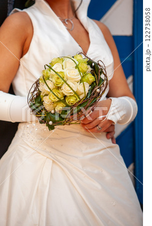 An Elegant Bride Radiates Charm with a Unique and Beautiful Floral Bouquet in Her Hands 122738058