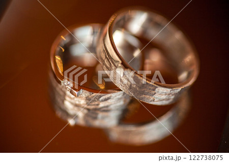 Beautiful and Elegant Wedding Rings Shown on a Reflective Surface for Enhanced Visual Appeal 122738075
