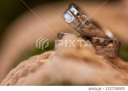 Beautifully Crafted Elegant Wedding Rings Displayed on a Natural Textured Background 122738083