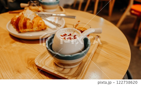 Cozy Morning Delight A Perfectly Brewed Coffee and Flaky Croissant on a Wooden Table 122738620