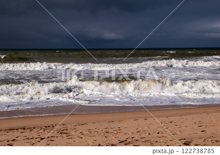 Empty wild sandy beach, Atlantic Ocean seascape, sea waves, beautiful cloudscape, dramatic landscape, travel content, Lisbon, Portugal 122738785