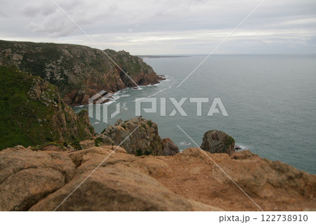 Panorama of the ocean coast and rock bay, Atlantic Ocean in winter, stormy sea waves with white lambs roll ashore with sheer rocks, beautiful cloudscape, dramatic landscape, gloomy seascape Panorama of the ocean coast and rock bay, Atlantic Ocean in winter, stormy sea waves with white lambs roll ashore with sheer rocks, beautiful cloudscape, dramatic landscape, gloomy seascape 122738910
