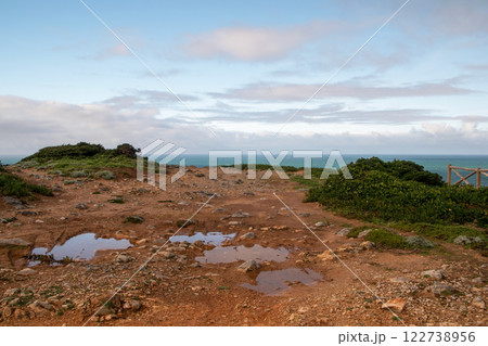 Panorama of the ocean coast and rock bay, Atlantic Ocean in winter, stormy sea waves with white lambs roll ashore with sheer rocks, beautiful cloudscape, dramatic landscape, gloomy seascape 122738956