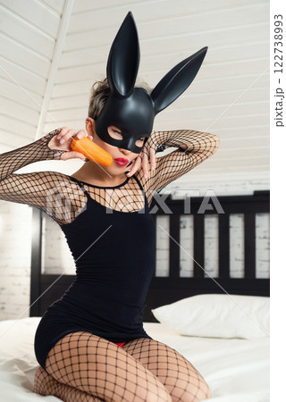 Sexy girl in a short black dress and a rabbit mask from a sex shop poses erotically in a mesh bodysuit Sexy girl in a short black dress and a rabbit mask from a sex shop poses erotically in a mesh bodysuit 122738993