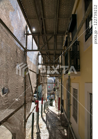 Reconstruction of facade of a historic apartment building on a city street, facade construction mesh covers an old house closed for renovation wall exterior Reconstruction of facade of a historic apartment building on a city street, facade construction mesh covers an old house closed for renovation wall exterior 122739212