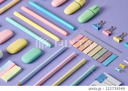 Stationery background with pastel-colored stationery neatly arranged on a light purple background. Stationery background with pastel-colored stationery neatly arranged on a light purple background. 122739349