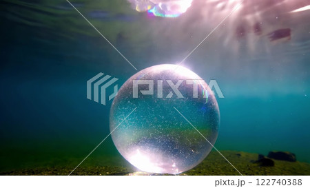 Crystal Ball resting underwater reflecting sunlight 122740388