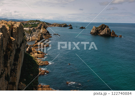 A stunning coastal view with dramatic cliffs and rock formations stretching into the blue ocean 122740884