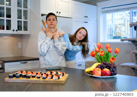 Teenagers laptop sushi bringing dish to dinner table 122740903