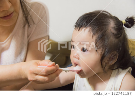 【離乳食を食べる髪を結んだ赤ちゃん】 【離乳食を食べる髪を結んだ赤ちゃん】 122741187