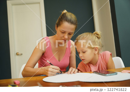 A mother and her young daughter engage in a colorful painting activity  122741822