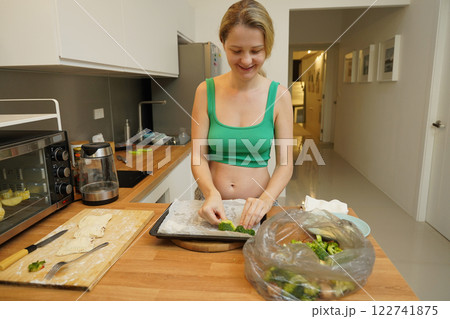 A young woman joyfully prepares a variety of healthy meals A young woman joyfully prepares a variety of healthy meals 122741875