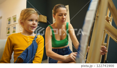 Teacher in workshop teched two girls how to assemble a thermo mosaic  122741900