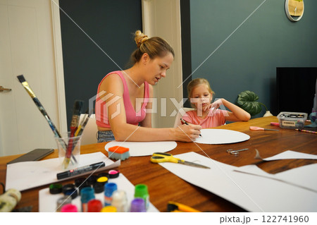 A mother and her young daughter engage in a colorful painting activity A mother and her young daughter engage in a colorful painting activity 122741960