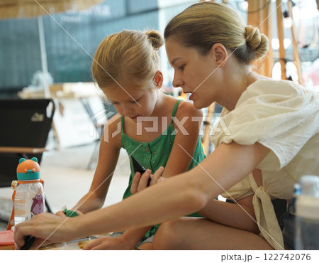 Mother and her daughter paint Halloween cookies  Mother and her daughter paint Halloween cookies  122742076
