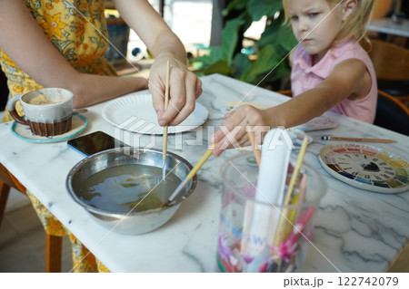 A young mother and her daughter enjoy a creative art session at home  122742079