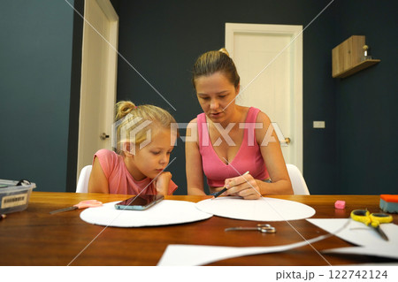 A mother and her young daughter engage in a colorful painting activity A mother and her young daughter engage in a colorful painting activity 122742124