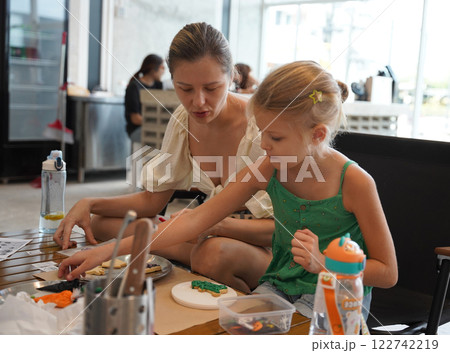 Mother and her daughter paint Halloween cookies Mother and her daughter paint Halloween cookies 122742219