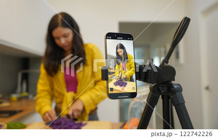 Young woman is broadcasting live from workshop how to prepare a vegetarian food Young woman is broadcasting live from workshop how to prepare a vegetarian food 122742226