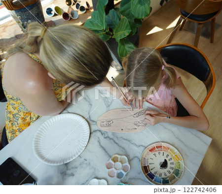 A young mother and her daughter enjoy a creative art session at home  122742406