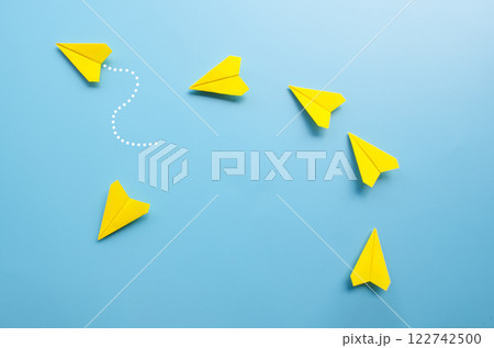 Top view of origami yellow paper airplane with one airplane leaving the group 122742500