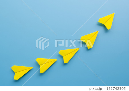 Top view of origami yellow paper airplane leading the flight with a vision for success. Leadership concept Top view of origami yellow paper airplane leading the flight with a vision for success. Leadership concept 122742505